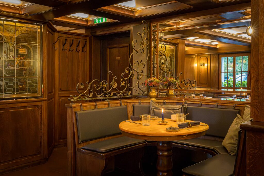 Ein gemütlicher Sitzbereich in einem Restaurant mit Holzmöbeln und dekorativen Elementen.