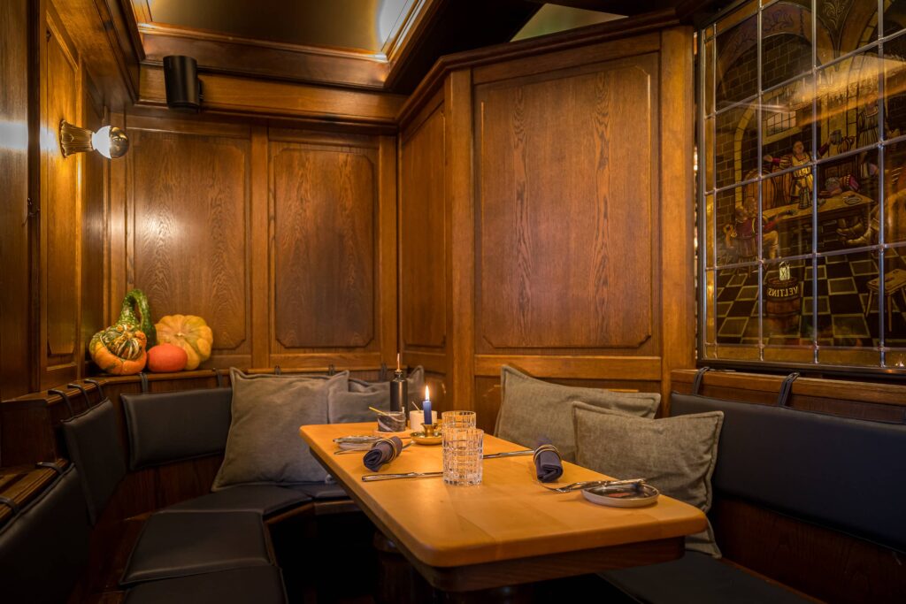 Holztisch mit Sitzgelegenheit und dekorativen Kissen in einem Restaurant.